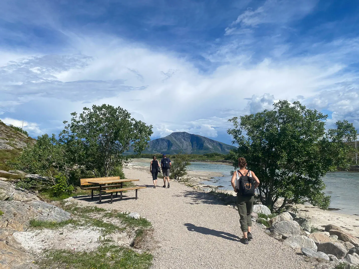 Nature-based recreational pathway integrated into a coastal landscape, featuring accessible surfaces, seating areas, native planting, and viewpoints overlooking the shoreline and surrounding mountains.